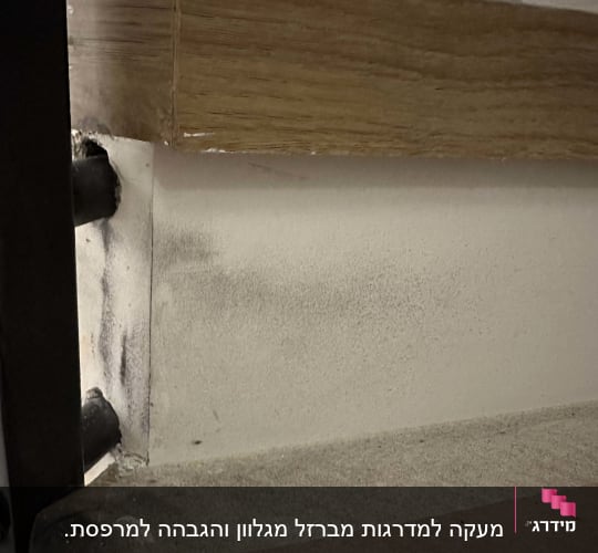 מדרגות עץ עם מסגרת מתכת בצד